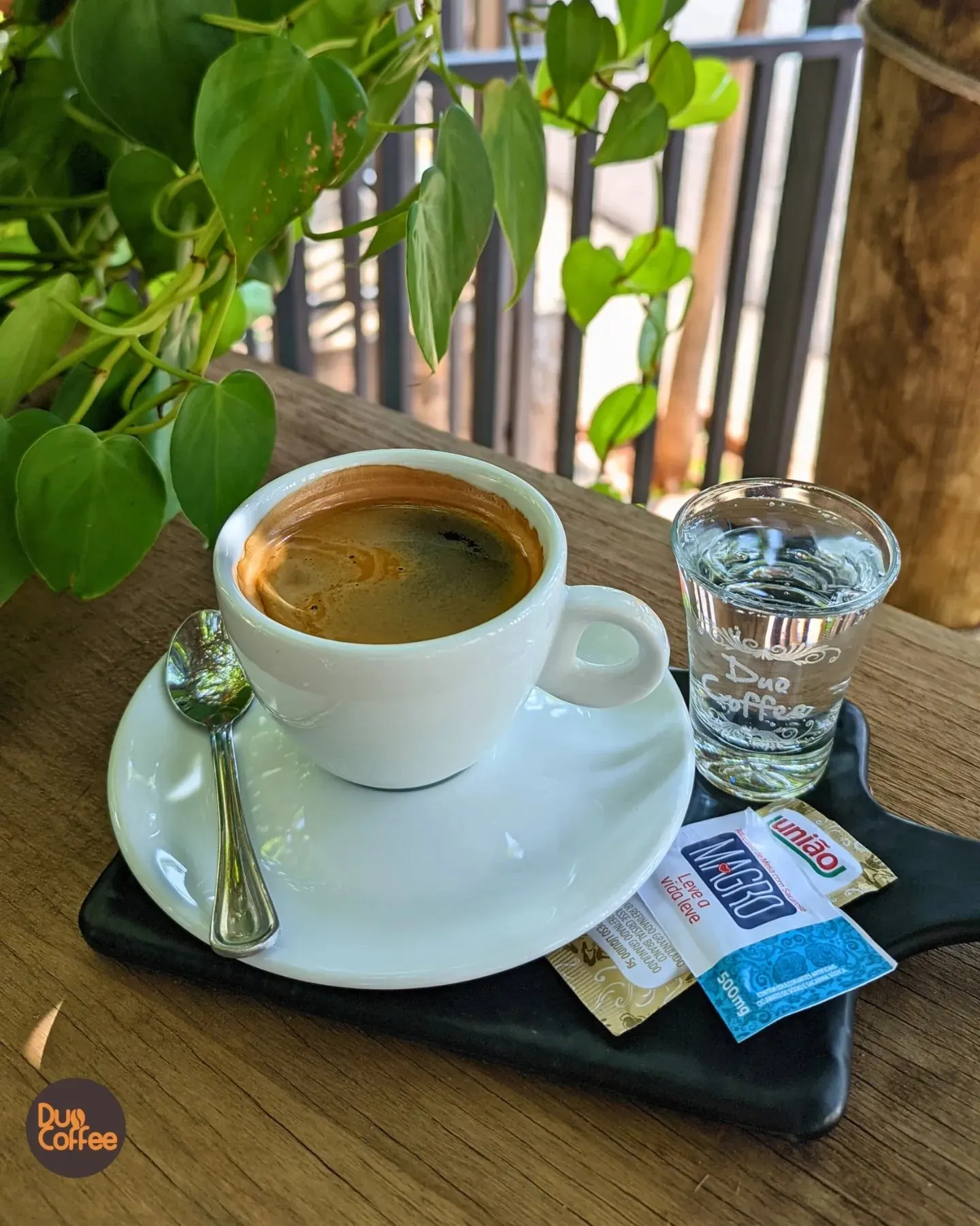 Café servido em xícara branca com copo d'água da Duo Coffee ao lado
